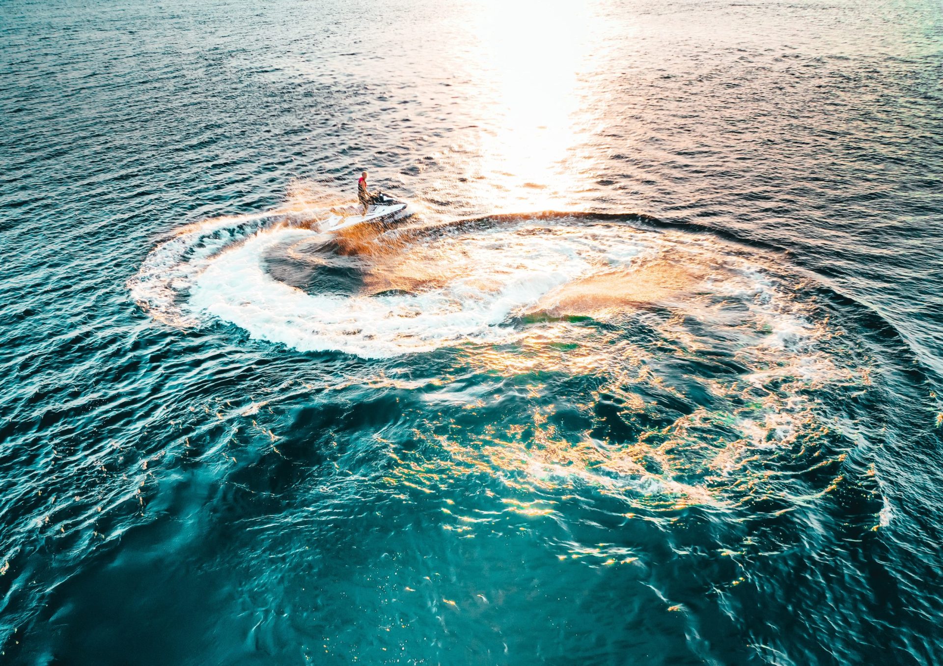 Moto de agua trazando una curva sobre el mar turquesa de Alicante al atardecer