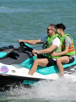 Dos personas en moto de agua navegando frente a la costa de Alicante